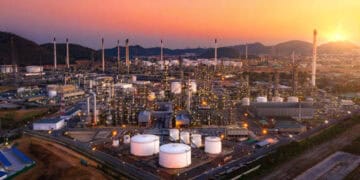 Aerial view of a large oil refinery at sunset. - Supply Chain News