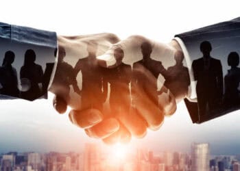 A group of business people shaking hands in front of a city, highlighting the evolving trends in US-China trade relations.