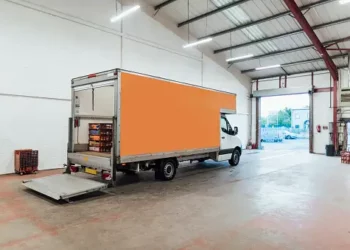 A van is parked in a large warehouse, ready for Amazon grocery delivery.
