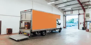 A van is parked in a large warehouse, ready for Amazon grocery delivery.