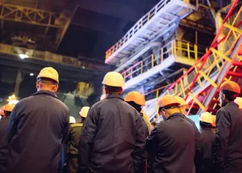 A group of workers in hard hats protesting a labor strike outside a coal mine.