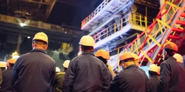 A group of workers in hard hats protesting a labor strike outside a coal mine.
