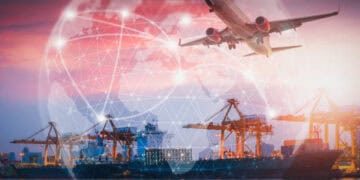 Global supply chain: cargo ship at port with airplane overhead, illustrating international trade and logistics challenges. - Supply Chain News