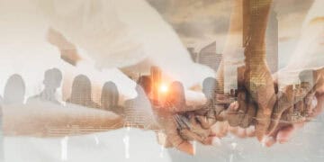 Chinese Foreign Minister Wang Yi on a visit to Washington, standing with a group of people holding hands in front of the city.