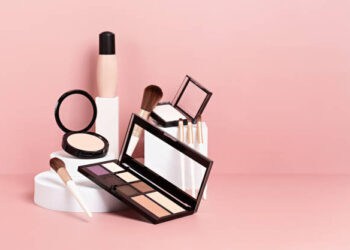Makeup products arranged on a pink background. Eyeshadow palette, powder, brushes, and foundation. - Supply Chain News