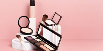Makeup products arranged on a pink background. Eyeshadow palette, powder, brushes, and foundation. - Supply Chain News