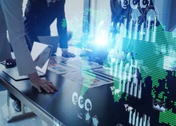Businesspeople collaborate on a table, analyzing global trade data visualized as a world map with charts and graphs. Biden's import restrictions on Russia impact is implied. - Supply Chain News