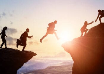 Silhouetted businesspeople collaborate, bridging a gap, symbolizing G7-Africa trade partnership. - Supply Chain News