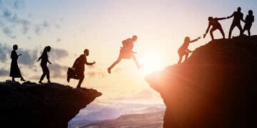 Silhouetted businesspeople collaborate, bridging a gap, symbolizing G7-Africa trade partnership. - Supply Chain News