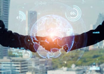 Two businesspeople shaking hands, a digital globe appearing between them, symbolizing international trade and a potential free trade agreement between Israel and Japan. - Supply Chain News