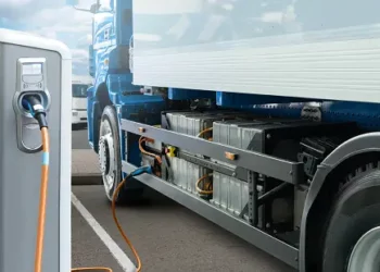 Electric delivery truck charging at a charging station. Sustainable logistics. - Supply Chain News