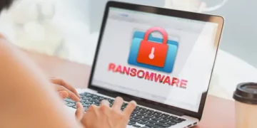 A person using a laptop to recover from a ransomware attack targeting MKS Instruments, a semiconductor supplier.