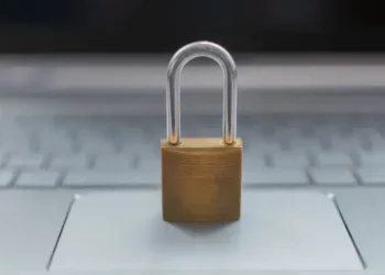 A padlock sits on top of a European laptop computer.