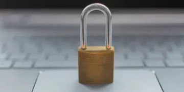 A padlock sits on top of a European laptop computer.