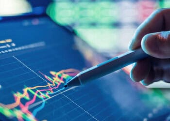 Stylus pointing at financial charts on tablet, illustrating climate-related financial risk management. - Supply Chain News