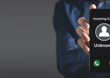 Person holding phone displaying "Incoming Call... Unknown". - Supply Chain News