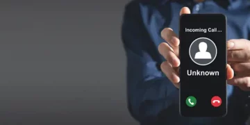 Person holding phone displaying "Incoming Call... Unknown". - Supply Chain News
