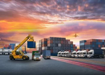 A truck carrying containers on a journey through Vietnam, with the magnificent sunset in the backdrop, symbolizing the country's digital aspirations and promising economic outlook.