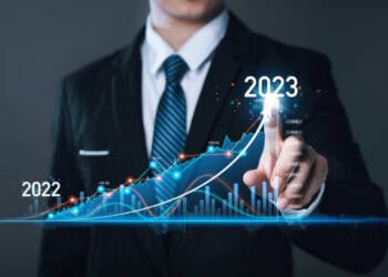 Businessperson points to upward 2023 growth trend on a graph, showing increase from 2022. - Supply Chain News