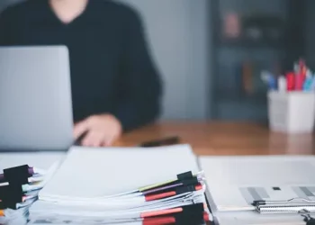 A person sitting at a desk with a laptop, ensuring fairness and transparency in their work with utmost diligence and compliance with SEC regulations.