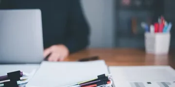 A person sitting at a desk with a laptop, ensuring fairness and transparency in their work with utmost diligence and compliance with SEC regulations.