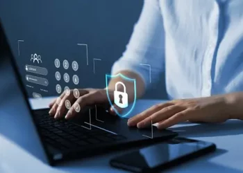 Person typing on laptop, securing online data with password and digital shield. Computing security. - Supply Chain News