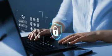 Person typing on laptop, securing online data with password and digital shield. Computing security. - Supply Chain News