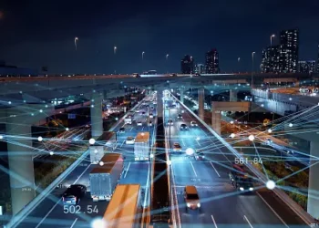 An image of a city at night with a network of connected cars showcasing security practices.