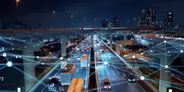 An image of a city at night with a network of connected cars showcasing equitable development in Indonesia's logistics sector.