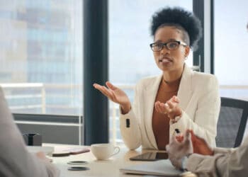 Three professionals in a meeting; a woman leads the discussion. - Supply Chain News