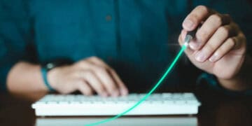 Person drawing upward trend graph on keyboard, symbolizing economic growth. - Supply Chain News