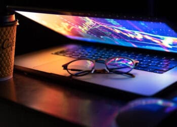 Laptop displaying stock market data; glasses rest on keyboard. Global trade analysis. - Supply Chain News