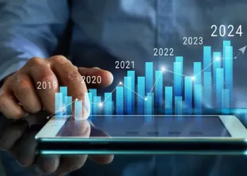 A man is pointing at a tablet with projections of prolonged inflation.