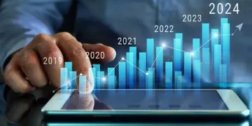 A man is pointing at a tablet with projections of prolonged inflation.