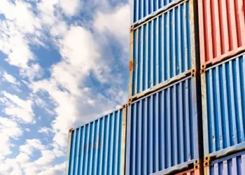 A stack of blue and red shipping containers against a blue sky, showcasing the BNSF railcars.