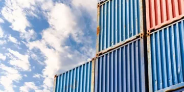 A stack of blue and red shipping containers against a blue sky, showcasing the BNSF railcars.