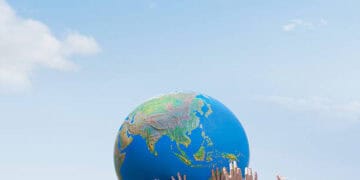 A group of people from Russia and Africa holding a globe in their hands, symbolizing cooperation.