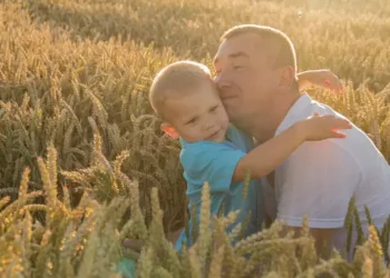 Father and son embracing in a wheat field. - Supply Chain News