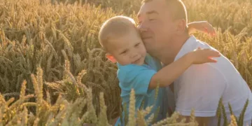 Father and son embracing in a wheat field. - Supply Chain News