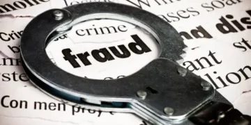 Handcuffs on newspaper with "fraud" highlighted; responding to financial crime. - Supply Chain News