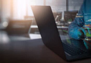 A man is using a laptop to analyze financial data related to U.S.-Africa Trade Relations during the AGOA Forum.