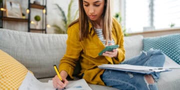 Woman reviewing financial documents, possibly related to OFAC sanctions on Hamas funding. - Supply Chain News