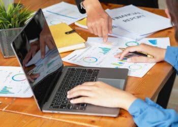 A group of people working on a laptop at a desk, focusing on crude oil trade.
