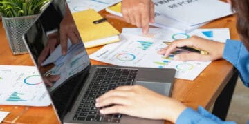 A group of people working on a laptop at a desk, focusing on crude oil trade.