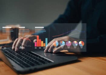 Person analyzing financial data on laptop, showing charts and graphs related to climate risk management in US banking. - Supply Chain News