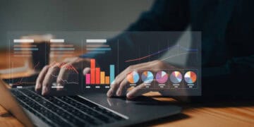 Person analyzing financial data on laptop, showing charts and graphs related to climate risk management in US banking. - Supply Chain News