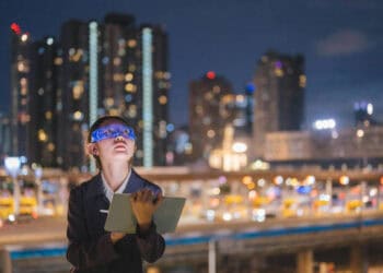 Businesswoman reviewing data on tablet at night. Global AML software market trends. - Supply Chain News