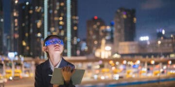 Businesswoman reviewing data on tablet at night. Global AML software market trends. - Supply Chain News