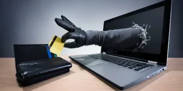 A laptop displaying a hand making a payment with a credit card.