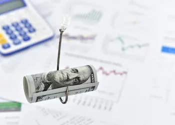 Rolled-up US dollar bill on a fishing hook over financial documents; beware of investment scams. - Supply Chain News